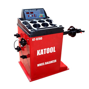 Red KATOOL KT-B700 wheel balancer with digital display, control buttons, and wheel mounting spindle for tire balancing.